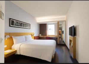 RewāriにあるTownhouse Dharuhera Bus Terminal Formerly Rewariのベッドとテレビがあるホテルの部屋