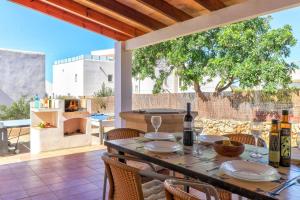 stół z butelkami wina i krzesłami na patio w obiekcie Villa Antonia Sol by Villa Plus w mieście Cacla D'or