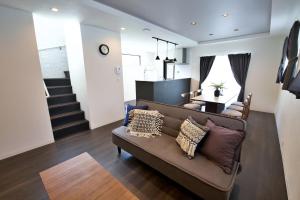 een woonkamer met een bank en een trap bij JUNGLIA House in Biimata