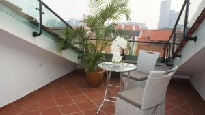 a balcony with a table and two chairs and plants at Heeren Straits Hotel in Malacca