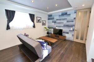 een woonkamer met een bank en een televisie bij JUNGLIA House in Biimata