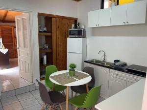a kitchen with a small table and green chairs at Apartamento Adriana in Cartago