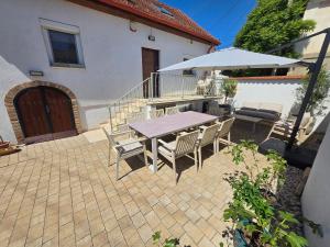 a patio with a table and chairs and an umbrella at FÜGE - Füredi füge terasz in Balatonfüred