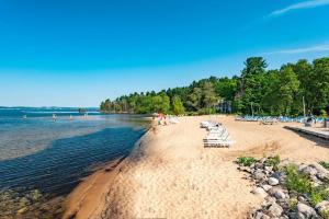 a beach with chairs and people on the water at Cozy Country Lakeside Condo 5705 in Traverse City