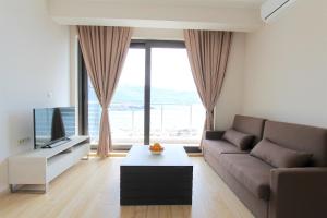 uma sala de estar com um sofá e uma televisão em Apartments Aqua em Budva