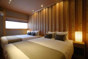 ein Schlafzimmer mit zwei Betten und einem Fenster in der Unterkunft オーシャンビュー BBQ可 最大8名 自然を満喫できる宿 Maru in Motobu