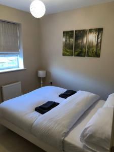 a bedroom with a large white bed with two towels on it at Cozy Sheffield Guest Room with Shared Facilities in Sheffield