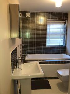 a bathroom with a sink and a tub and a toilet at Cozy Sheffield Guest Room with Shared Facilities in Sheffield