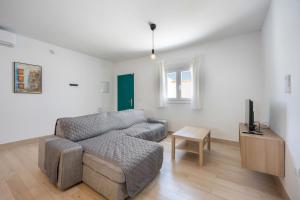 ein Wohnzimmer mit Sofa und Fernseher in der Unterkunft Casa de la Noria in Chiclana de la Frontera