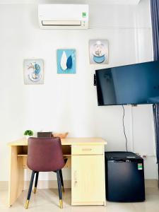 a desk with a chair and a television on a wall at Sunrise Homestay in Danang +13 photos
