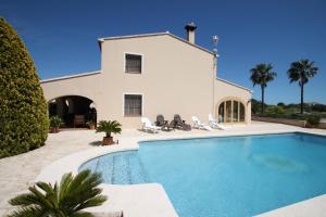 a swimming pool in front of a house at Finca Cantares - holiday home with private swimming pool in Benissa in Benissa