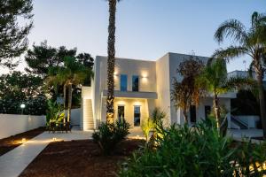 a white house with palm trees in front of it at Fontanelle Seaside in Fontanelle