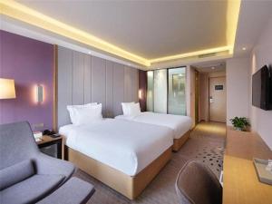 a hotel room with two beds and a couch at Lavande Hotel Yangzhou Railway Station Jiangwang RT-Mart in Yinjiahu +55 photos