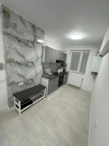 a kitchen with a marble wall in a room at Apartament Ultra Central 4 in Hunedoara
