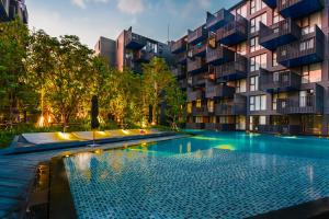 a swimming pool in front of a building at The Deck Condominium by Lofty in Patong Beach