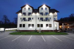 a large white building with a parking lot at night at Amso Residence in Sibiu