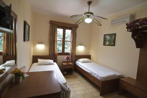 - une chambre avec 2 lits et un ventilateur de plafond dans l'établissement Mango Rooms, à Rhodes