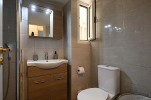 a bathroom with a toilet and a sink and a mirror at Patision cinema apartment in Mesochórion +35 photos