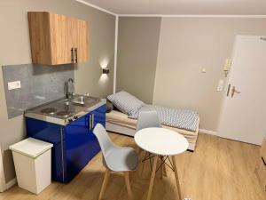 una pequeña cocina con fregadero, mesa y sillas en Upscale Apartments in Bergisch Gladbach, en Bergisch Gladbach