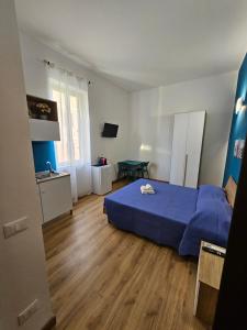 a bedroom with a blue bed and a kitchen at Luna Rossa in Ladispoli