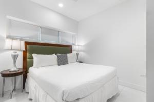 a bedroom with a white bed with a green headboard at Arubas Life 207 in Noord +53 photos