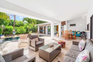 a living room and dining room with a pool at Vayu - Eco Chic House Tamarin in Tamarin