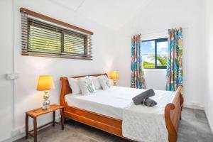 a bedroom with a bed and a table and a window at Vayu - Eco Chic House Tamarin in Tamarin