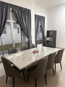 a dining room with a large table and chairs at Xiang Homestay in Padang Serai +3 photos