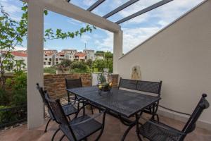 a patio with a table and chairs on a balcony at Villa Suzy Lux in Sutivan