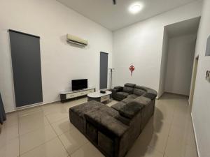 a living room with a couch and a flat screen tv at Xiang Homestay in Padang Serai