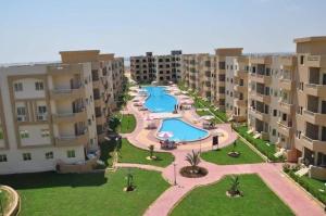 an aerial view of an apartment complex with a swimming pool at شاليه بقرية تاهيتي الساحل الشمالي in Al Ḩammām