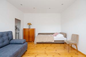 a living room with a bed and a couch at Spacious House with Parking & Garden by Noclegi Renters in Warsaw