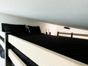 un letto in una camera con materasso bianco e nero di Studio Lumineux Mezzanine à 10 minutes de Disney a Serris