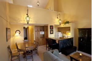 a living room and kitchen with a table and a couch at Innwest Kirkwood Inn in Kimberley