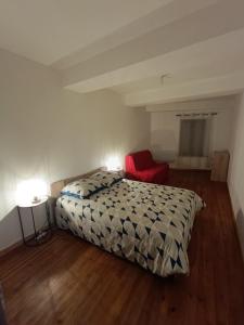 a bedroom with a bed and a red chair at La terrasse des Augustins in Limoux +29 photos