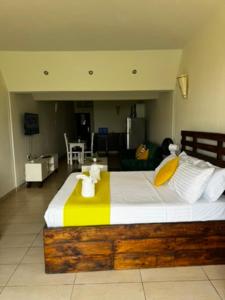 Un dormitorio con una cama grande con una manta amarilla y blanca. en Diani Fisherhut Studio, en Diani Beach