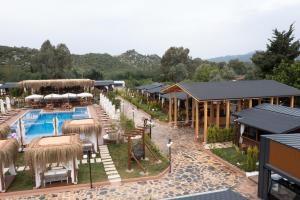 a resort with a swimming pool and tables and chairs at Kekova Garden Village in Demre
