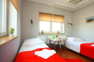 a hotel room with two beds and a table and a dining room at Hostel Bazar in Kraków