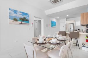 a dining room with a glass table and white chairs at Arubas Life 108 in Noord