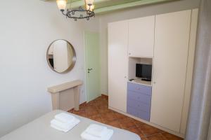 a white room with a bed and a mirror at Villa Ostria in Koufonisia