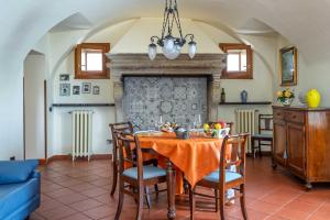 a dining room with a table with chairs and a fireplace at San Carlo Appartamenti vacanze in Soiano del Lago