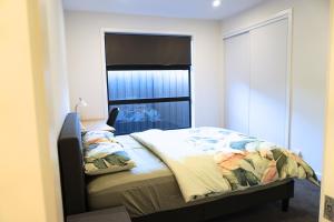 a bedroom with a bed with a large window at Brand New Home with Private Rooms in Tottenham