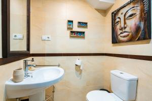 a bathroom with a sink and a toilet with a face on the wall at Duplex Torre La Sal Magic World in Cabanes +20 photos