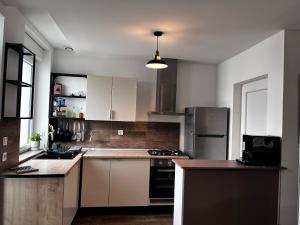 a kitchen with white cabinets and a stove top oven at Confortable Maison in Les Rues-des-Vignes