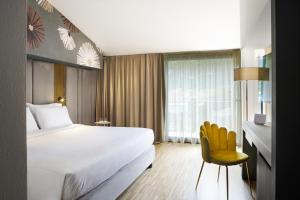 a bedroom with a bed and a desk and a chair at Astoria Resort in Riva del Garda