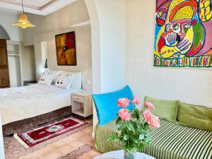 a bedroom with a bed and a couch and a painting at Riad Safran Ralya in Marrakesh +115 photos