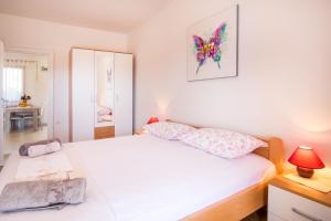 a bedroom with a white bed and a mirror at Apartments Iva in Krk