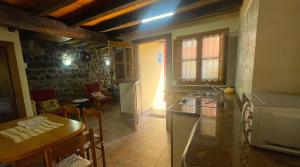 a kitchen with a table and a dining room at Casa El Collau I in La Frecha