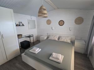 a bedroom with a bed with two towels on it at Къщички Морски Светулки in Sinemorets