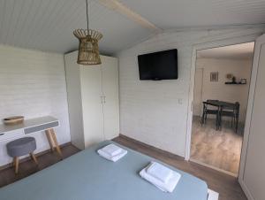 a room with a bed and a tv on a wall at Къщички Морски Светулки in Sinemorets